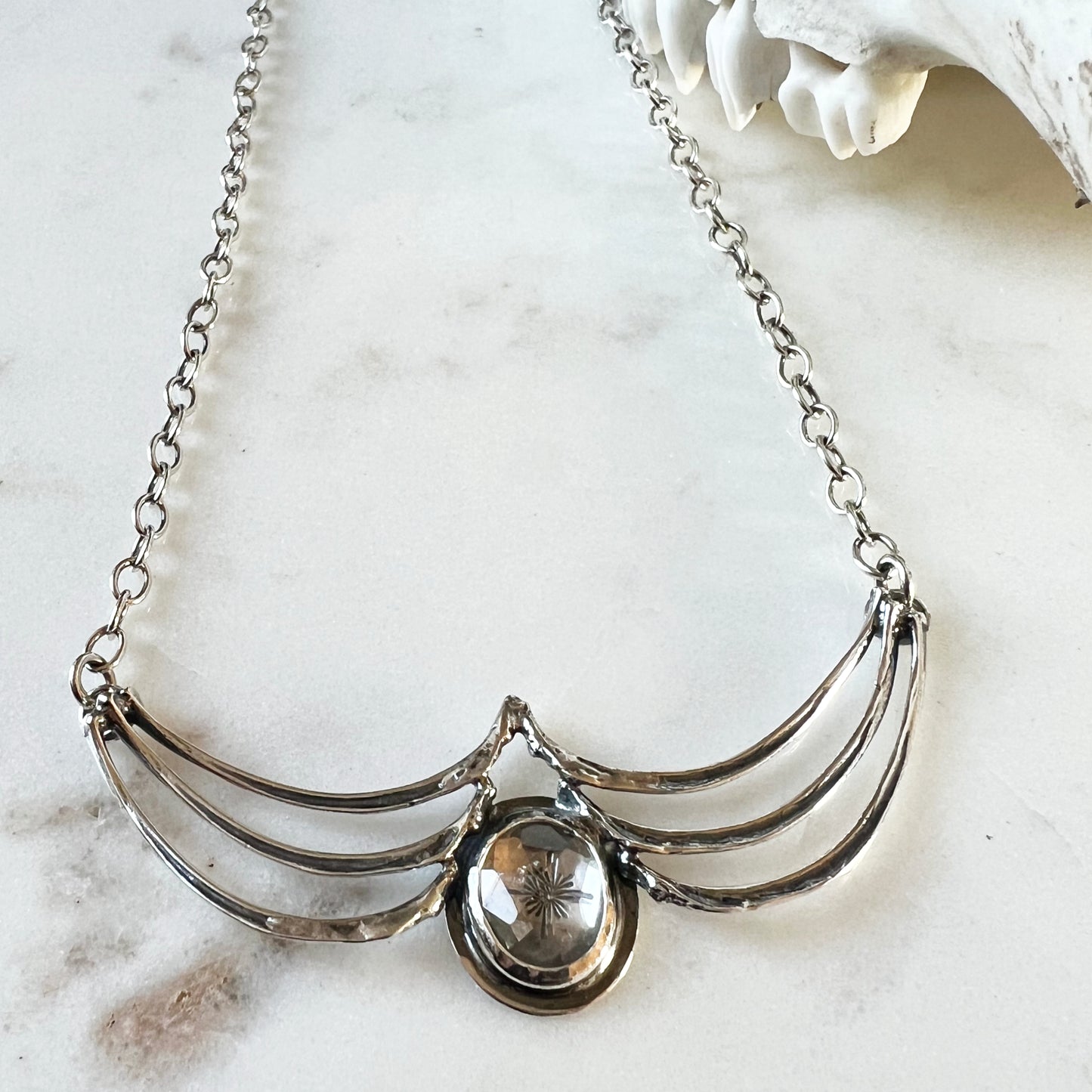 Squirrel rib necklace with clear faceted topaz