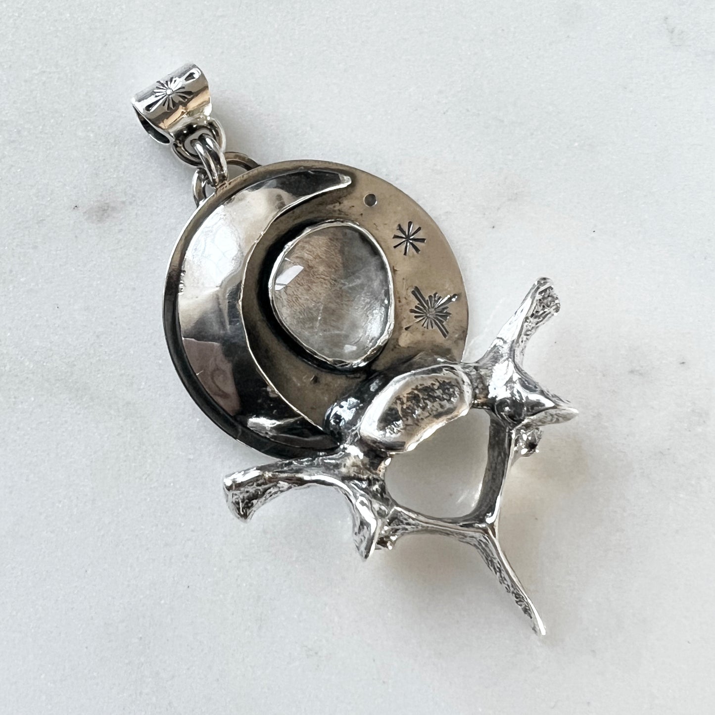 Moon and raccoon vertebra pendant with faceted clear topaz