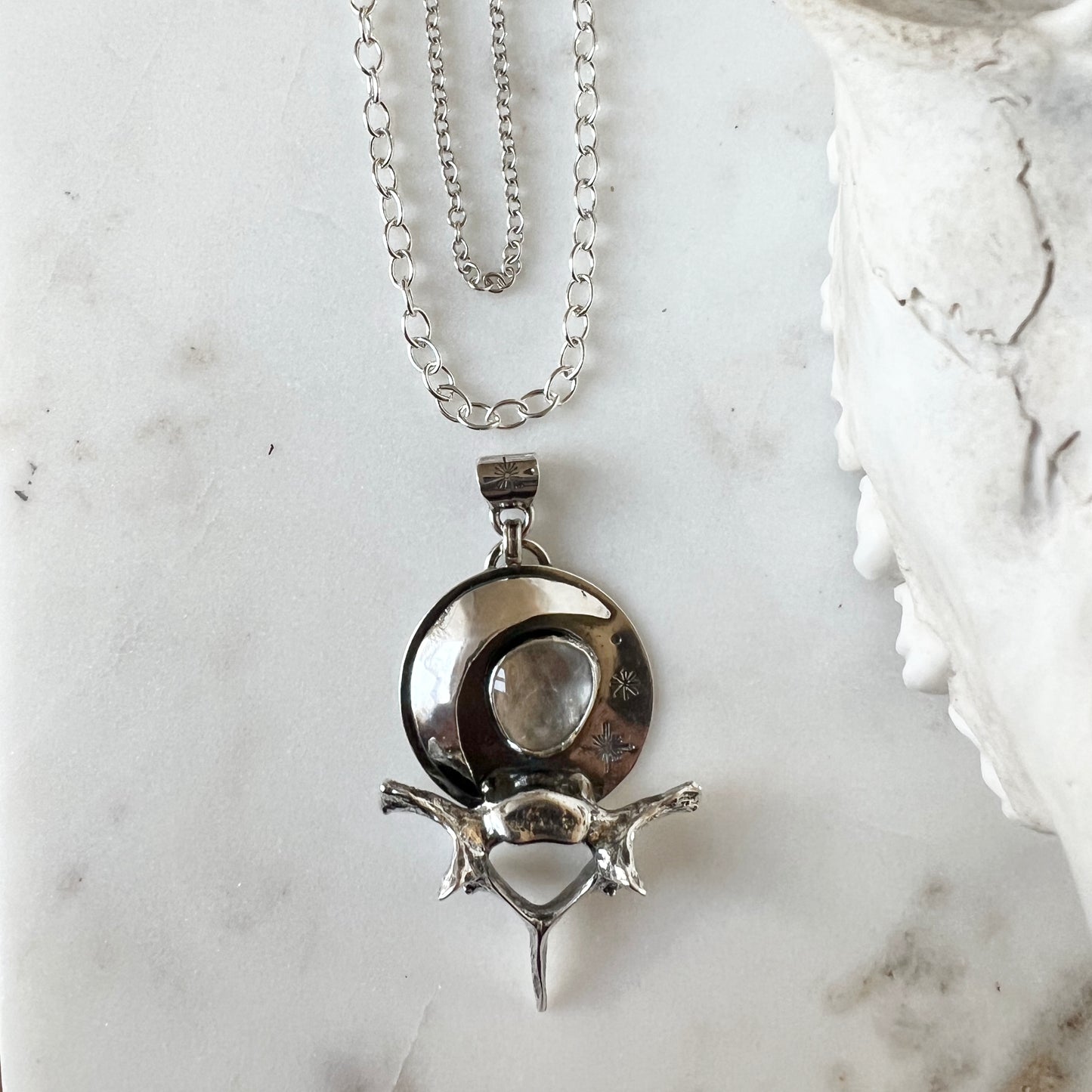 Moon and raccoon vertebra pendant with faceted clear topaz