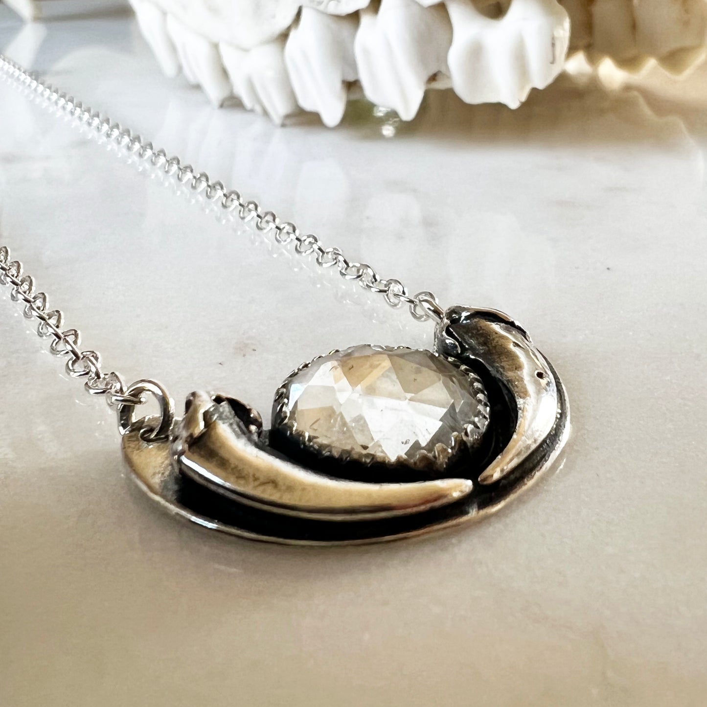 Fox claw crescent necklace with clear faceted topaz